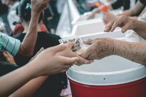 Feeding concept Homeless people offer free food from outdoor volunteers. photo