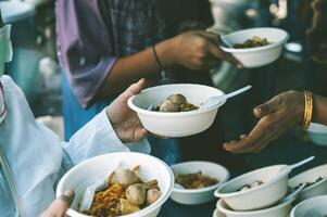 Hungry homeless people request free food donations from volunteers social concept of helping photo