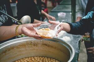 el ayuda de voluntarios ayuda a donar gratis comida a el muriendo de hambre gente. foto