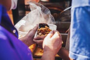 Volunteers serving hot meals to hungry migrants humanitarian aid concept. photo