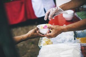 comida asistencia a el Vagabundo pobre desde voluntarios conceptos de público hambre. foto