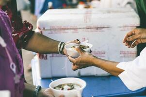 Volunteers are giving free food to help the hungry poor concept of food sharing photo