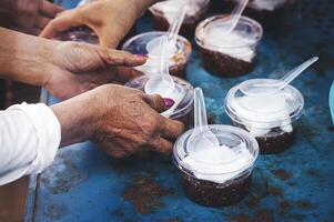 manos de hambriento personas preguntando para gratis comida desde voluntarios humanitario ayuda concepto foto