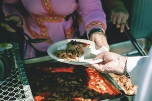 Volunteers offer free food to the poor. the concept of food sharing. photo