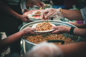 volunteer serving food to the homeless in the Community Charitable Donation Center Concept of free food assistance service photo