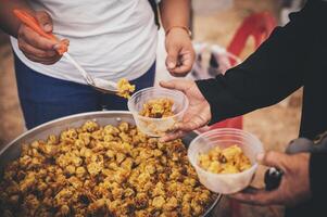 Volunteers distribute simple meals to the poor at the free food kitchen. photo