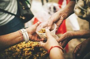 voluntarios dar comida a el pobre, compartir gratis comida a ayuda mendigos comida donación concepto foto