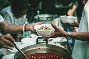 Volunteers serving hot meals to hungry migrants humanitarian aid concept. photo