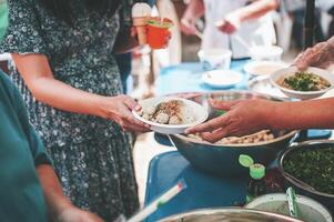 voluntarios dar comida a el pobre, compartir gratis comida a ayuda mendigos comida donación concepto foto