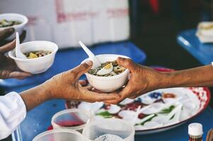 Volunteers serving hot meals to hungry migrants humanitarian aid concept. photo