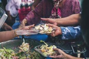 Volunteers serving hot meals to hungry migrants humanitarian aid concept. photo