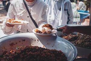 volunteer serving food to the homeless in the Community Charitable Donation Center Concept of free food assistance service photo