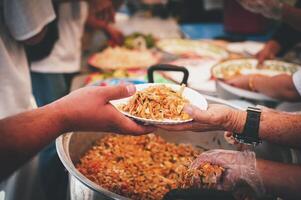 Homeless people reach out to receive free food that volunteers bring. to help alleviate hunger photo