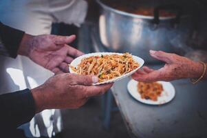 Volunteer to serve free food for the poor in a food donation center charity concept photo