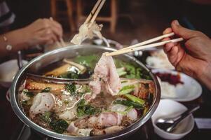 Hot pot with clear soup, Pork, fish, vegetables, blanched in hot broth and dipped in a variety of sauces. photo