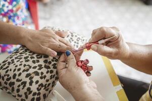 Manicurist is decorating the nails for the beauty of the hands. photo