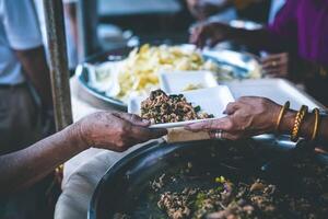 manos de hambriento personas preguntando para gratis comida desde voluntarios humanitario ayuda concepto foto