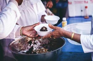 Volunteers are giving free food to help the hungry poor concept of food sharing photo