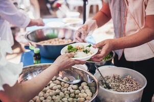 manos de hambriento personas preguntando para gratis comida desde voluntarios humanitario ayuda concepto foto