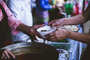 Hungry homeless people request free food donations from volunteers social concept of helping photo