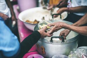 comida asistencia a el Vagabundo pobre desde voluntarios conceptos de público hambre. foto