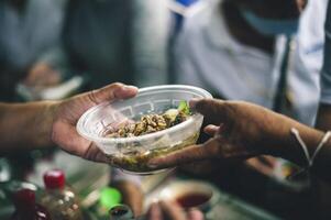 comida asistencia a el Vagabundo pobre desde voluntarios conceptos de público hambre. foto