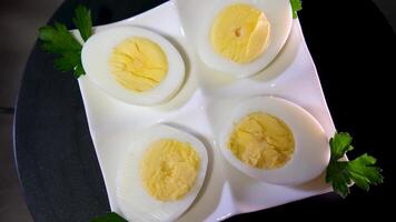 hervido huevos para desayuno. en un blanco lámina. negro antecedentes video