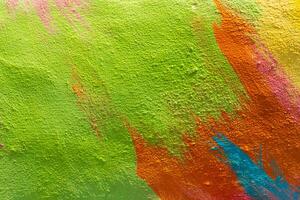 A fragment of colorful graffiti painted on a wall. Abstract urban background. Spray painting art. photo