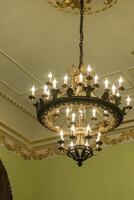 Close up shot of the decorative walls, ceiling and chandelier. Interior photo