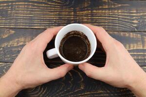 Cup with coffee grounds in hands photo