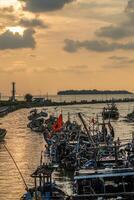 Jepara, Central Java, April 7, 2024 - Jepara fishing boats parked in a crowded harbor against the backdrop of the evening sky with empty space for advertising photo