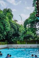 jepara, central Java, abril 14, 2024 - nadando piscina paseos rodeado por arboles son lleno de visitantes durante vacaciones. foto