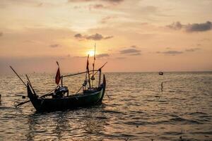 fishing boats on the sea against an orange sky at night with empty space for photocopies. photo