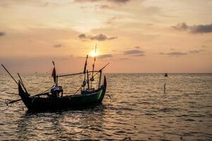 fishing boats on the sea against an orange sky at night with empty space for photocopies. photo