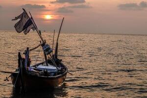 fishing boats on the sea against an orange sky at night with empty space for photocopies. photo