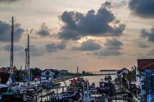 Jepara, Central Java, April 7, 2024 - Jepara fishing boats parked in a crowded harbor against the backdrop of the evening sky with empty space for advertising photo