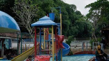 jepara, central Java, abril 14, 2024 - nadando piscina paseos para niños con vistoso diapositivas foto