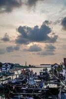 Jepara, Central Java, April 7, 2024 - Jepara fishing boats parked in a crowded harbor against the backdrop of the evening sky with empty space for advertising photo