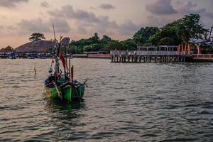 Fishing boats leaning on the seashore with the Kartini Beach tourism in Jepara, Central Java in the background. photo