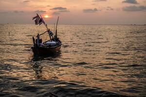 fishing boats on the sea against an orange sky at night with empty space for photocopies. photo