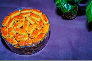 Close-up view of Kastengel cake with cheese sprinkles, neatly arranged in a jar. photo