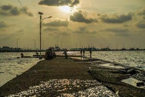 jepara, central Java, abril 7, 2024 -pescadores a el jepara muelle con un puesta de sol cielo como el antecedentes con gratis espacio para fotocopias. naturaleza concepto para publicidad. foto