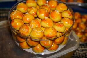 Close-up view of pineapple cake in a transparent jar on the table. photo