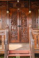 The front view of a classic wooden house, full of distinctive carvings with Javanese Indonesian nuances. photo