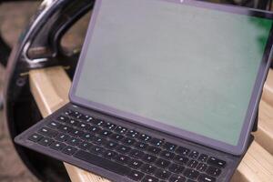 ordenador portátil tableta con blanco pantalla en parque banco. foto