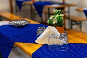 mesa con un azul Manteles y un florero de flores foto