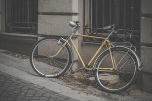 un antiguo bicicleta en el acera en frente de un casa foto