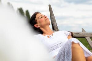 un mujer en un blanco vestir con un blanco fantasía nube en el primer plano foto