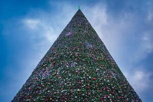 Artificial Christmas tree in garlands at twilight. photo