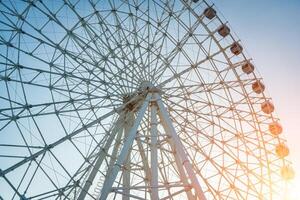 ferris rueda a puesta de sol o amanecer en un diversión parque. foto